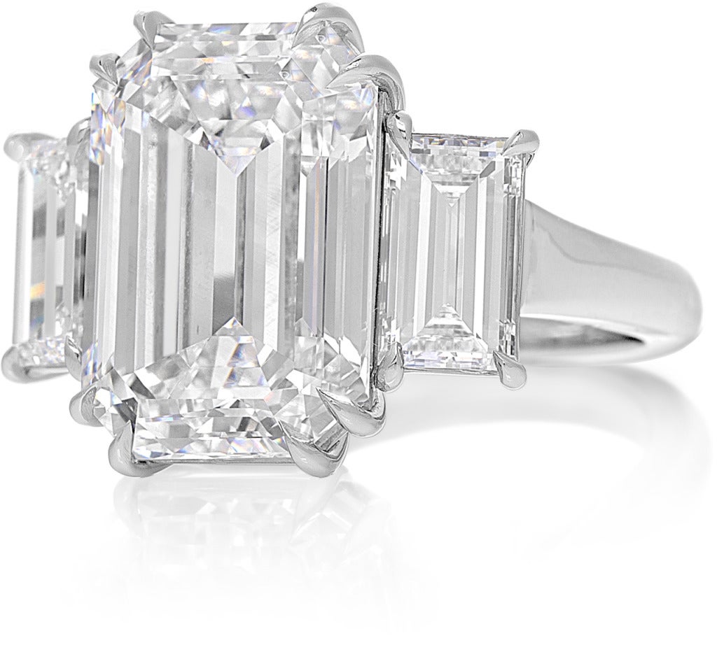 A beautiful handcrafted three stone engagement ring.  Set with a 10.03 carat Emerald-cut F color diamond GIA certified Internally flawless clarity.  The center diamond is flanked by  two Emerald-cut diamonds 1.09 & 1.03 carats GIA certified. Set