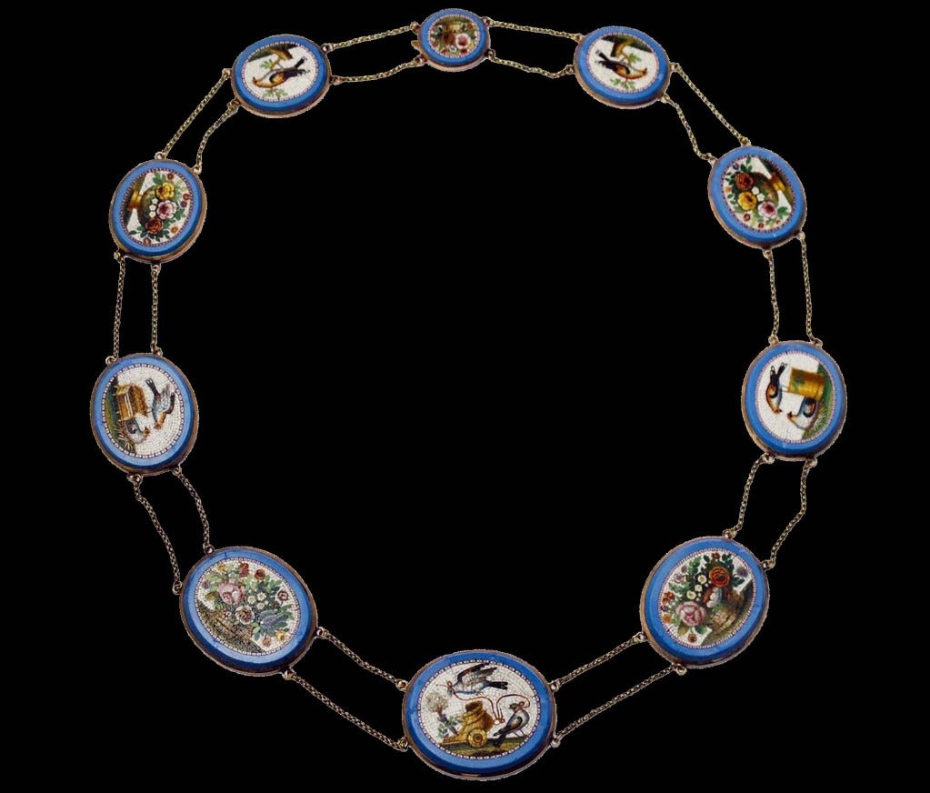 A Yellow gold necklace composed of ten micromosaic plaques on blue glass-paste and of a thin double chain. The plaques represent baskets of flowers and doves (allegory of maternal love ). Rome, 1830.