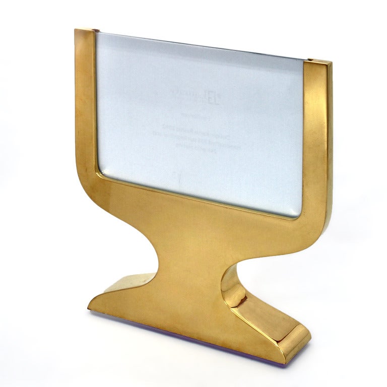 Equilibrium Gold is a picture frame in silver 925  goldplated
designed by Karim Rashid . It is a very simple and modern 
piece and can be suitable to hold one or two photos, front and back. The piece has been designed same shape front and back
as