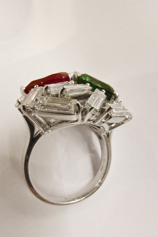 A white gold Mouawad ring set with three pear-shaped color stones : emerald, ruby and sapphire. The three stones are embellished by a set of baguette-cut diamonds for a total weight of about 4 carat. 
Stones origin : The emerald is bresilian, the
