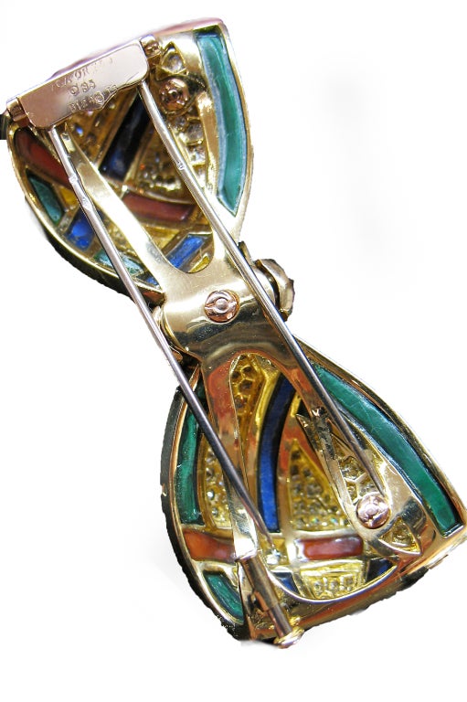 A colorful yellow gold Van Cleef & Arpels knot brooch set with diamonds, lapis lazuli, coral and malachite stripes.

Diamonds weight : approximately 3.50 carat.
Length : 6.6 cm.
Height : 2.2 cm.
Circa 1980.