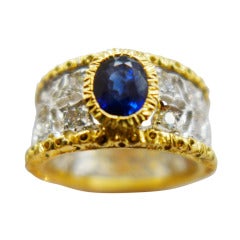 Two colors of gold Buccellati ring set with a sapphire and diamonds.