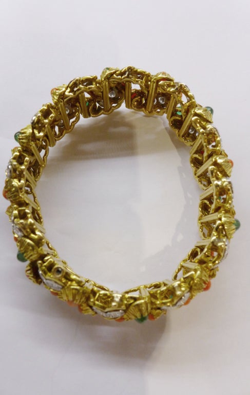 A yellow gold and platinum Boucheron bracelet foliage design, set with thirty six coral beads, twelve cabochon cut emeralds and brilliant-cut diamonds.

Length: 19 cm.
Circa 1970.