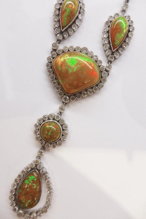 Platinum necklace set with five opals. Each opal is surrounded by circular-cut diamonds. 
Height of the three opals in the center : 70 mm 
Certified by the French Gemological Laboratory : Ethiopia