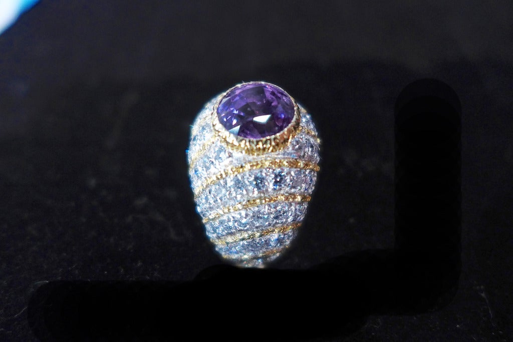 A yellow and white gold Gianmaria Buccellati ring made with diamond waves and a round violet sapphire in the middle of the ring. 
Approximate sapphire weight : 2,50 carat. 
Finger size : 4,5 cannot be sized. 
Presumed Retail price : $34,000