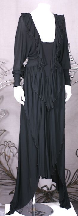 Amazing draped matte jersey and satin gown with interesting construction. A satin insert reminiscent of an 18th Century corset forms the bodice of this gown. Black matte jersey super long sleeves and pointed skirt panels fall from the bodice. Jersey