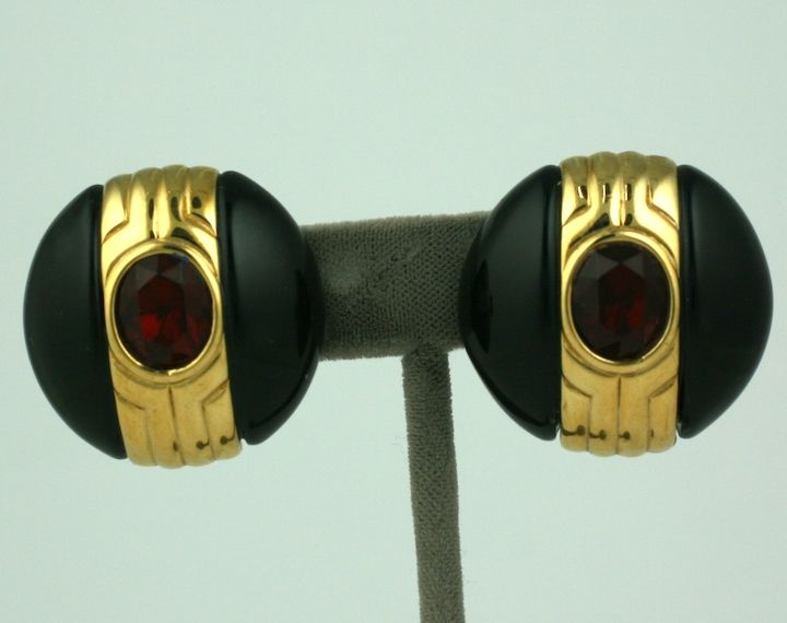 Large clip earrings from Givenchy, Paris circa 1980s. Black bakelite is accented with gilt metal and a ruby paste.<br />
1 3/8