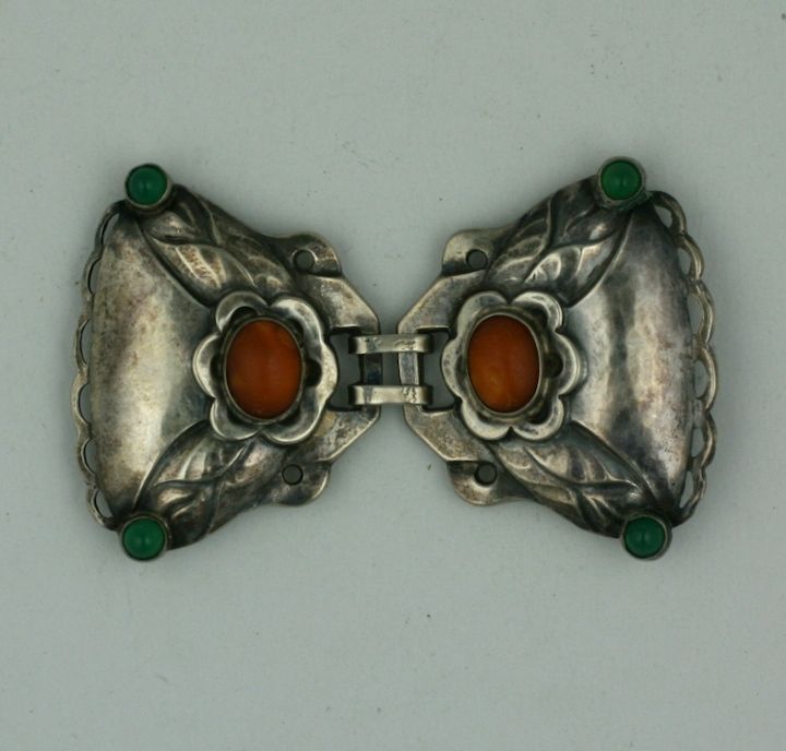 Art nouveau buckle made by Georg Jensen from the early 20th Century. Early hallmarks of his art nouveau/arts and crafts style are visible in this hand wrought sterling buckle hand set with cabochon crysophrases and amber. Rare and early Jensen