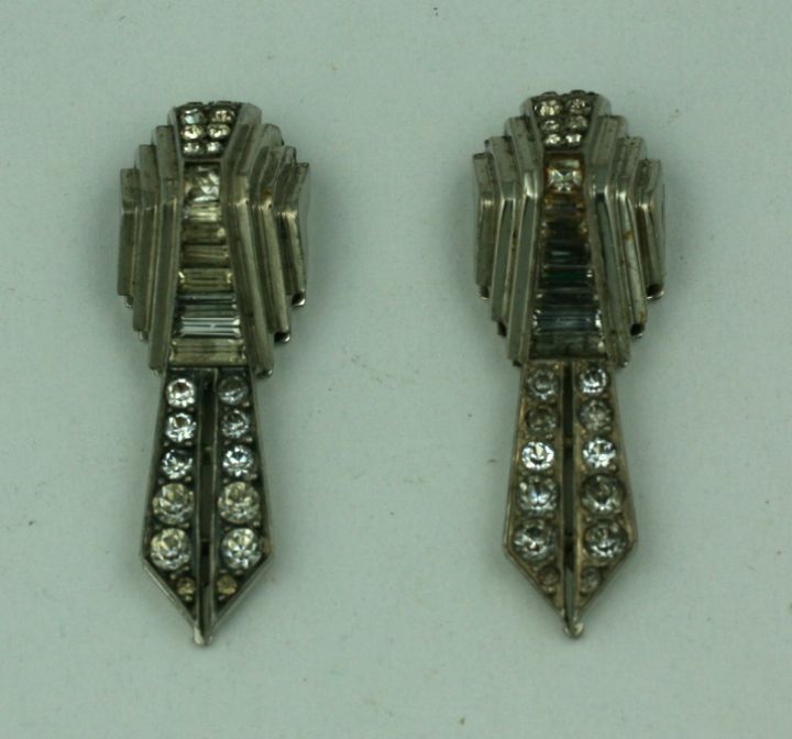 A matched pair of art deco sterling silver and hand set paste dress clips of round and baguette cut with the silver chevron stepped side mounts. 1930's France. Excellent condition.