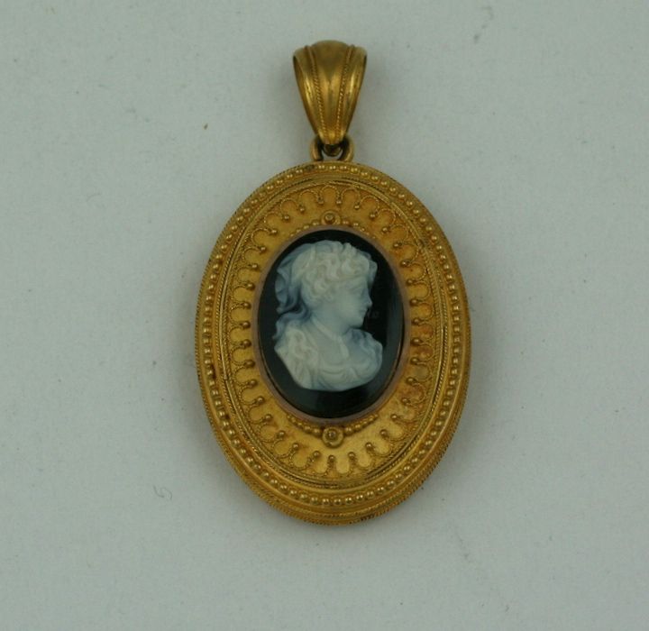 Victorian stone cameo locket circa 1880 of black and white carved agate. The hinged locket of 14kt gold with fine granulation and wire work, containing a beveled glass useable <br />
picture frame.<br />
Excellent Condition<br />
2