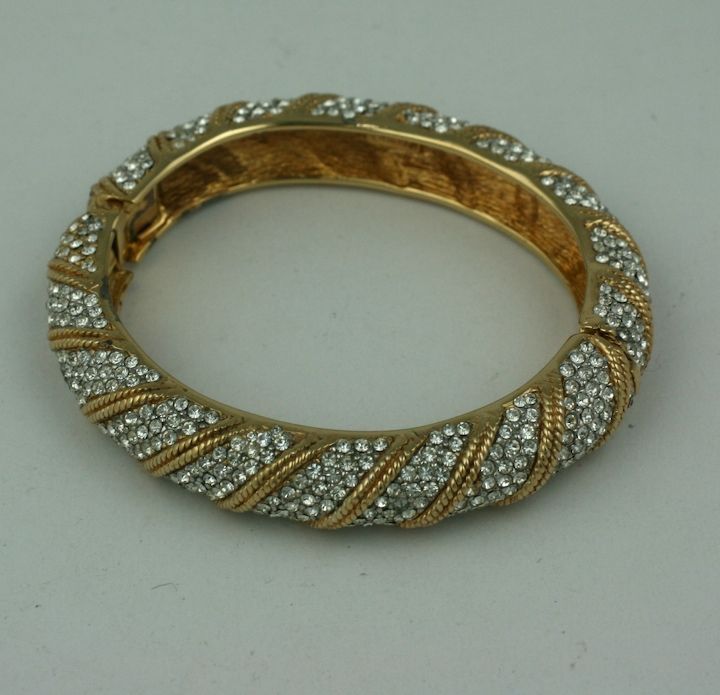 Bracelet doré de Ciner N.Y. à bandes diagonales pavées et motifs de corde dorés. années 1960 USA.<br />
Diamètre intérieur 2
