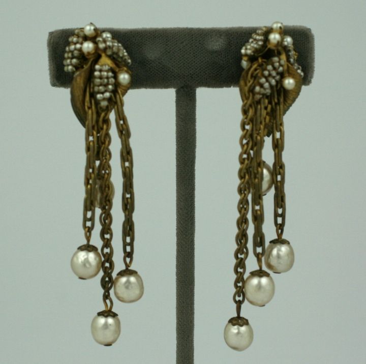 Exquisite Miriam Haskell-Ohrringe aus signiertem russischem Gold mit Perlen. Saatperlen sind entlang lilienförmiger Funde gestickt, wobei die Perlentropfen an Ketten aufgehängt sind, die von der Mitte jedes Blütenkopfes ausgehen.
Ajdustable clip