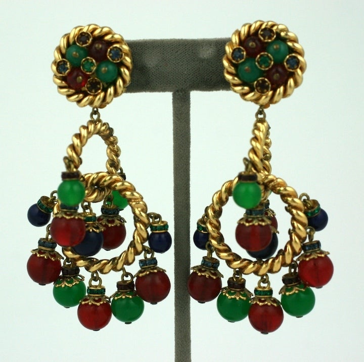 Ornate french earclips with paste rondels, resin, glass elements on ribbed gilt alternating hoops by Francoise Montague. Ruby, emerald and sapphire colorations.
 Very unusual and attractive from many different angles. Clip back fittings 1990's.