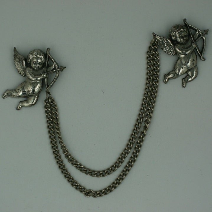 Charming sweater pins of silvered cupids attached with a chain made by Coro in the 1950s. Excellent condition.<br />
1.5