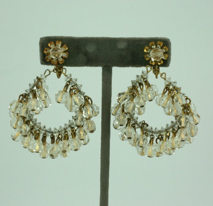 Miriam Haskell's large hoop earring of dangling round cut crystals in russian gilt metal with signature flower head  tops. Adjustable clip fittings.<br />
Excellent condition.