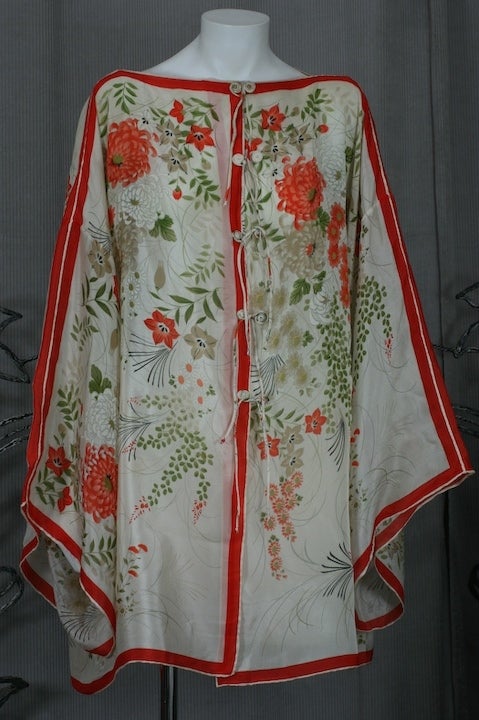 Unusual japanese silk coverup made from 4 identical scarves. Wide Kimono sleeves with bias self ties down the front. Crystanthemum print in oranges, greeen on white ground.
Excellent condition.