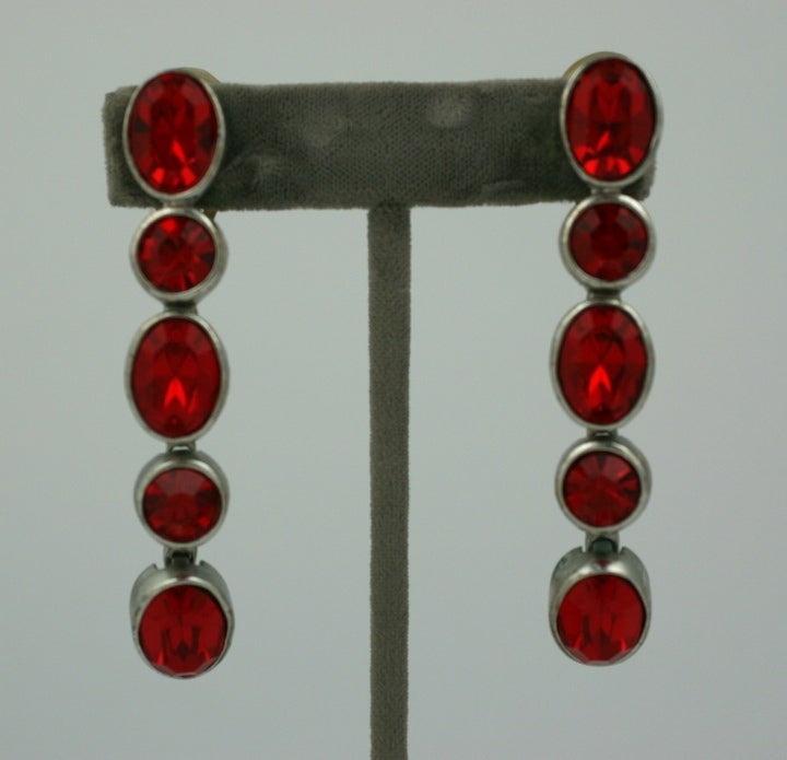 Long Yves Saint Laurent dangle earrings of bezel set oval ruby pastes. Articulated to move with wearer. Silvered metal, Made in France. 1980's. 3