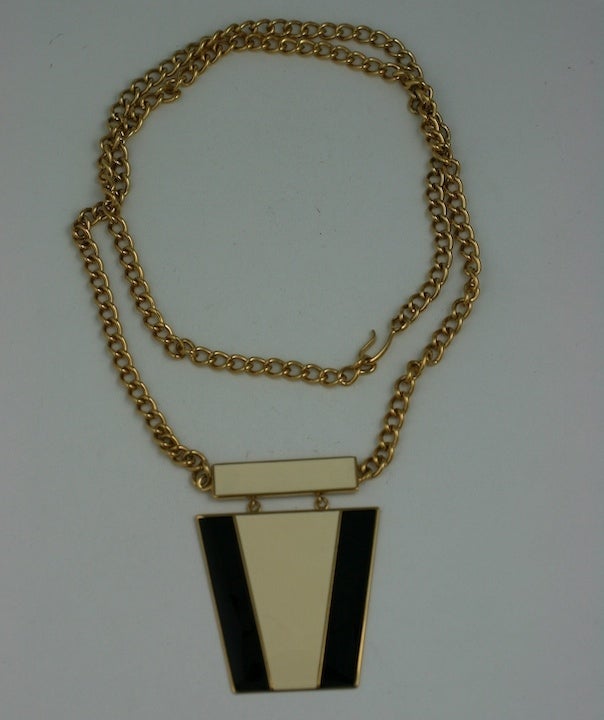 Attraente collana con ciondolo in stile Art Modern con smalto color crema e nero. Lunga catena con motivo centrale pendente. Anni '80 USA.
Condizioni eccellenti.
