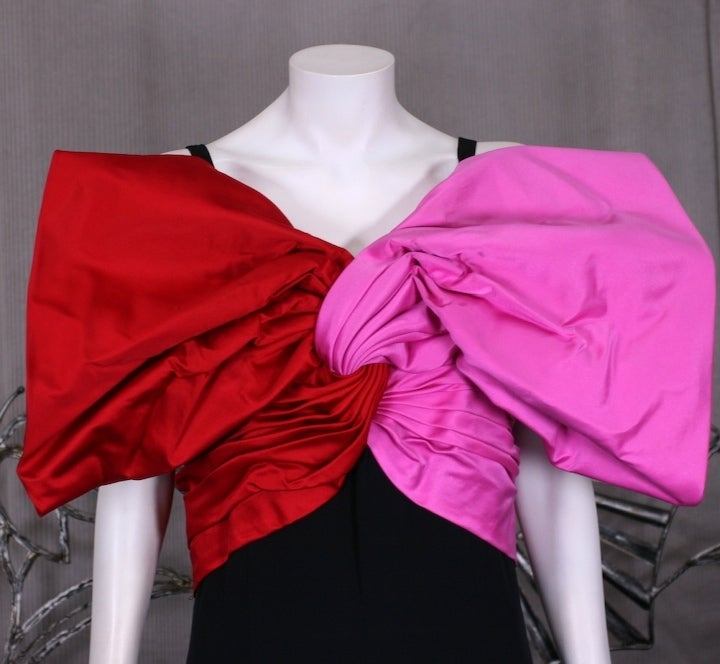 Extravagant and iconic Bill Blass 2 toned Silk Taffeta Bow Gown with black silk crepe body. Dramatic design which creates a faux wrapped bow across bust and shoulders in ruby and hot pink silk satin. Black silk crepe column base with high back slit