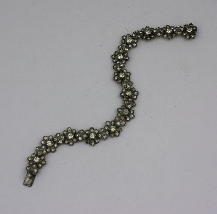 Preciosa pulsera de eslabones con flores articuladas de principios del siglo XX, engastada en plata de ley. Las piedras en pasta se han patinado hasta adquirir un brillo suave. 
Excelente estado, 1900 EE.UU. 
7.25