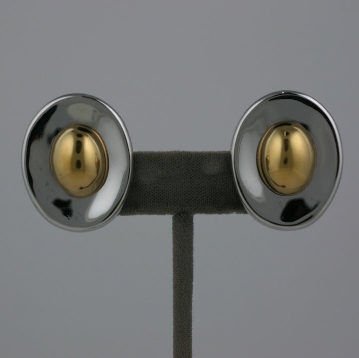 Attraenti orecchini Ciner composti da un ovale concavo in cromo con un cabochon ovale dorato. Accessori a clip. Anni '80, USA. 1.25