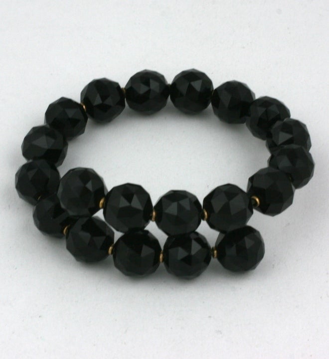 Beautifully faceted 10mm onyx beads with gilt spacers on a tension wrap bracelet from the late 19th Century. Steel wire core helps to retain shape of this Victorian mourning bracelet. Modern and timeless, 2