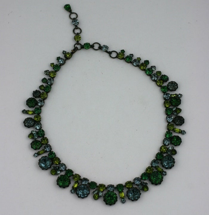 Attractive rhinestone-set necklace from the 1950's. Unusual combination of colors include emerald, deep aqua and peridot in round and baguette shapes. Set into antiqued blackened bronze so the colors really pop.  Austria 1950's.  
Adjusts from