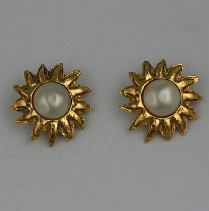 Chanel sunburst motif earrings in gilt metal with faux mabe pearl. Clip back fittings. France 1980s.  1 3/8