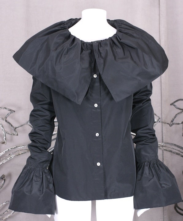 Taffeta silk blend blouse by Yohji Yamamoto with massive self doubled ruffles at neck and wrists. Extra long sleeves meant to scrunch up arm. Victorian in spirit with reproportioned details.  France 1980s. Unworn.
Size 2 label, 40-40-40, Length
