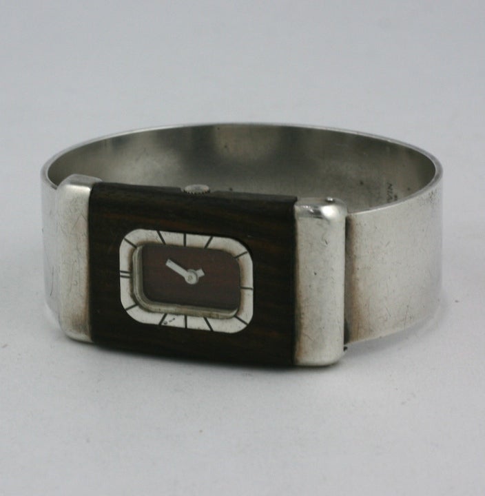 Great rare Lanvin bangle watch in wood and sterling silver from the 1970's. Hard bangle clamper with attractive moderne design.
Watch is set into wood face which is set in sterling. Bangle is silvered metal. Watch runs beautifully. 1970's