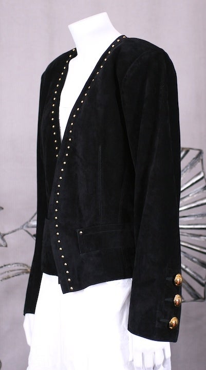 Strong shouldered YSL heavy black suede jacket with gold stud adornments. Strong elegant proportions as only YSL can cut.
Massive golden domed buttons edge up each cuff. 2 large slash pockets with stud ornamentation at nipped waist (without
