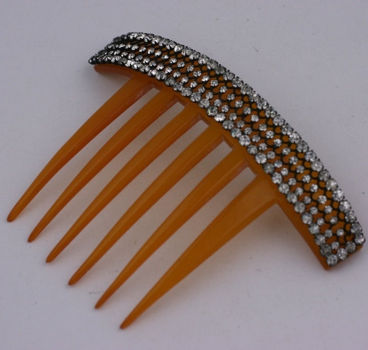 Attractive comb with a fretwork of varisized crystals on a blond celluloid base. Wonderful condition, late 19th Century. 4.75