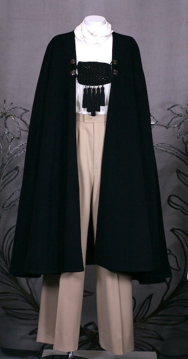 Dramatic and incredibly chic full circle cut black wool cape with passementerie and tassel trim buttoned closure. Wonderful and rare model from YSL's Russian collection. Mid 1970s France.
Excellent condition.