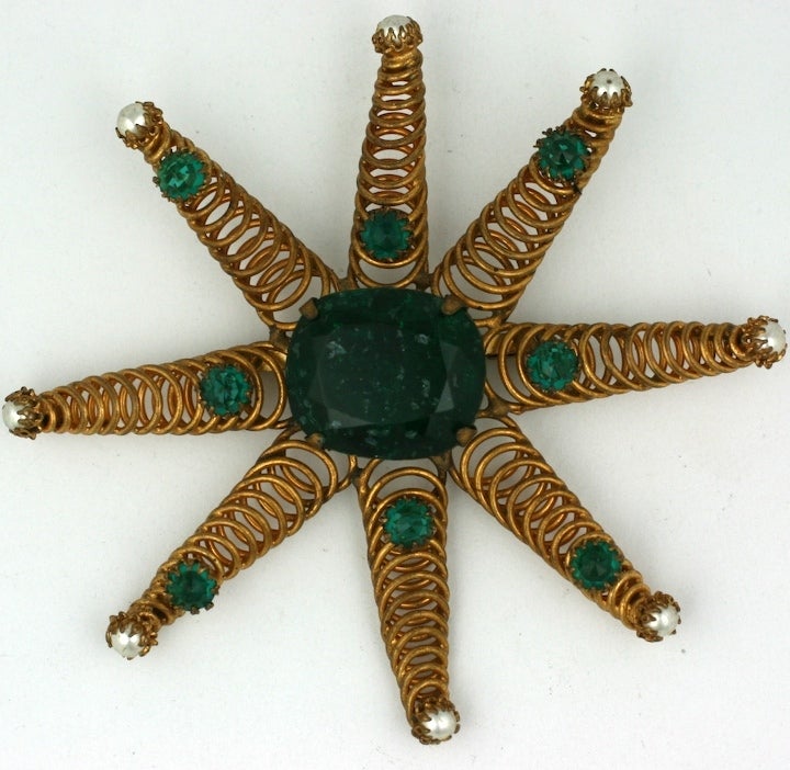 Rare signed Countess Cis coiled star brooch,the center emerald stone of glass infused with mica, faux pearls, and emerald faceted rounds. Excellent condition.  1950's France.

Countess Cis born in Vienna, she started her career in jewelry in 1951