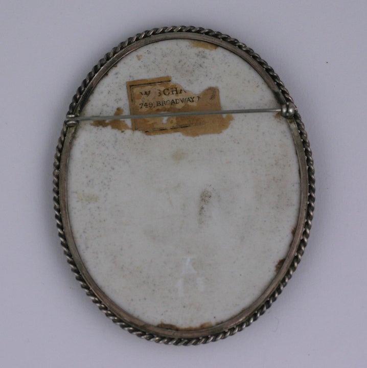 Broche putti de gran tamaño de finales del siglo XIX. El putti está decorado sobre una base de porcelana con detalles de pintura dorada. Un bisel de plata retorcida mantiene la placa en su sitio y probablemente se aplicó 30 años después. Hay una