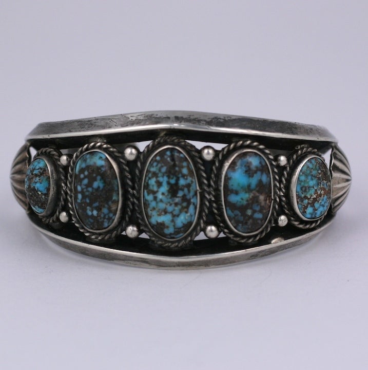 Attractive Navajo cuff of graduated turquoises set in silver with twisted wire and shot work. Great for men or women. Interior 2.5 x 2