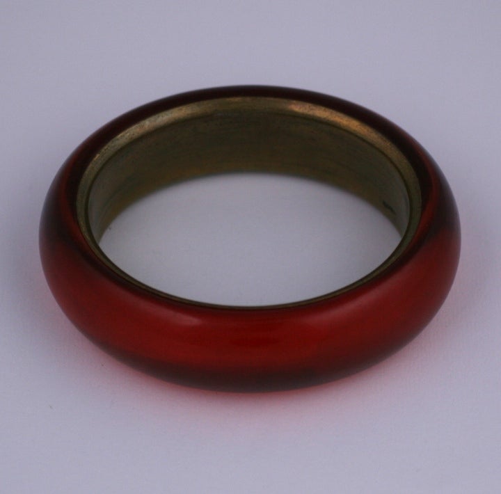 Attractive lucite bangle in a cherry amber tone. Completely 