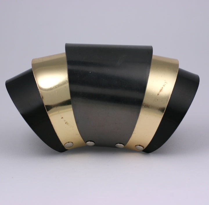 Unusual hinged tri toned cuff of gunmetal, gold and black metal. Hinged from underneath to expand and close with wearer.Strong and bold 1980s design. 4.5