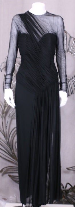 Elegante y sexy vestido drapeado de ilusión elástica de Vicky Tiel sobre una base de jersey mate. La ilusión se frunce en los hombros y se frunce a lo largo del corpiño y se libera en un panel fruncido que flota sobre un vestido de punto mate doble