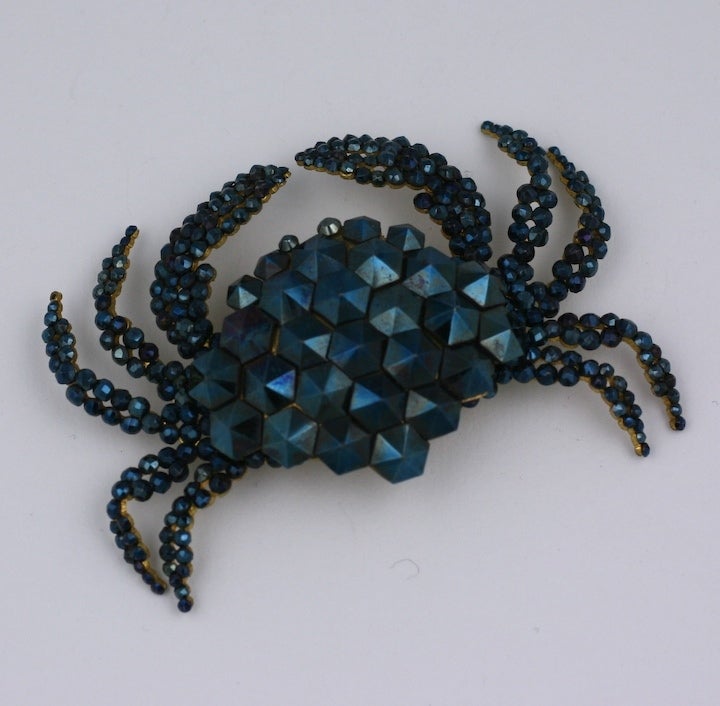 Incredibly contemporary looking crab brooch made of iridized cut steel. This brooch is highly unusual because of its coloring and construction. Spike shaped beads cover the back and tiny faceted cut steel beads pave the crab's legs. The iridized