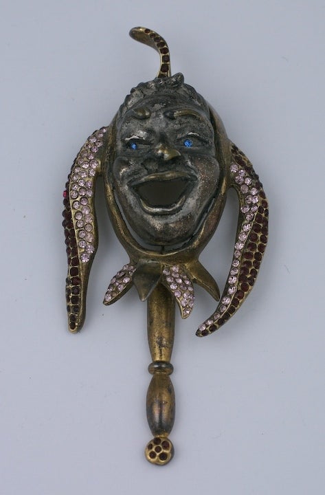 This large jester brooch is a later recast of a 1940's period brooch. Set in gilt and silvered metal with pink and ruby pastes.
The jeweled stick below swings with wearer. 4.5