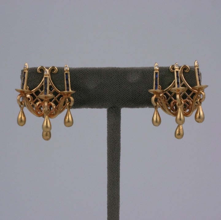 Charming and unusual 14K retro earrings in the form of candle sconces set with baguette sapphires and diamond flamed tips. Sconces are often considered jewelry for the room, here they are decoration for your ears.
Small golden drops replicate the