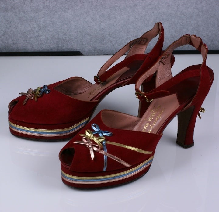 Amazing and unusual platforms in bright red suede with metallic baby blue, pink, and gold bow detailing. Motif is repeated on the heel as well and the back of the strap with decorated red suede hearts. Maker: Henry Waters, Size 8N, 25mm long x 7mm