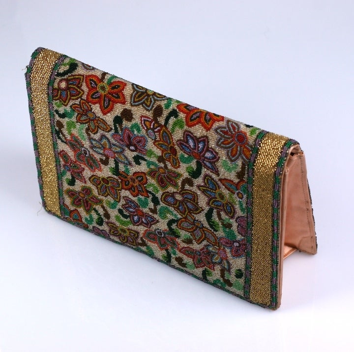 Art deco clutch with an all over microbeaded rug pattern. Edges beaded in gold with satin lining. 1930's. 5.5
