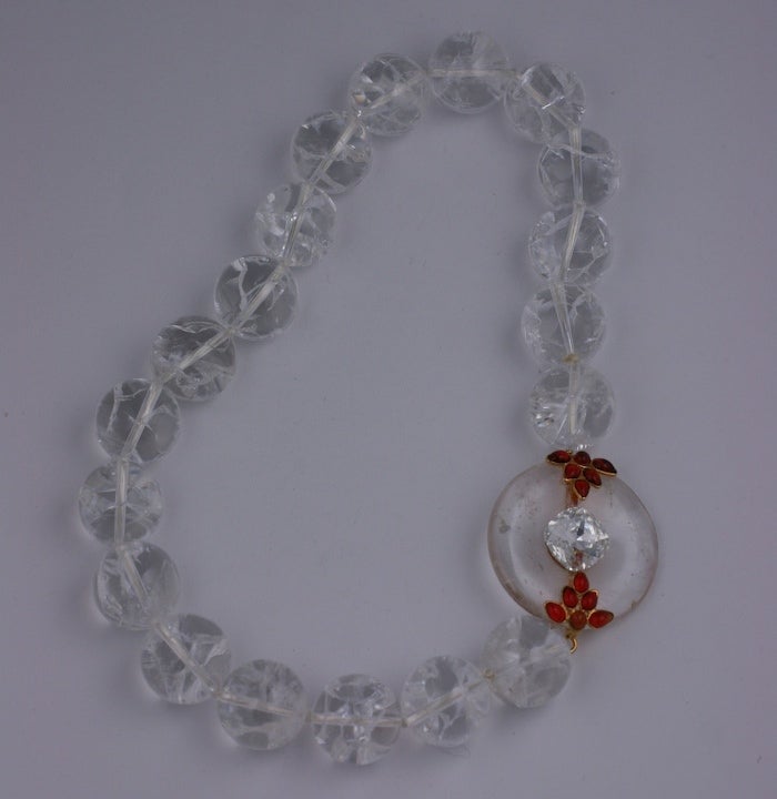 MWLC rock crystal bead necklace with Pi clasp set with ruby poured glass motifs and a large cushion cut Swarovski paste. 
The Pi is a Chinese symbol representing Eternity and dates back to 4500 BC. 
Made by hand in the Paris studios of Mark Walsh
