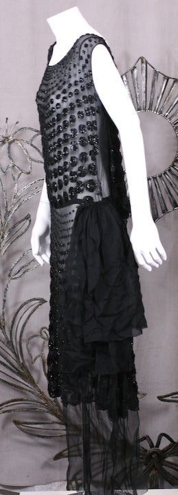 French art deco dress of black beaded dots which graduate from small to large across bodice and skirt on silk chiffon base. Beautiful quality workmanship. The dress has a waist where a chiffon sash is caught up on the hip. 43