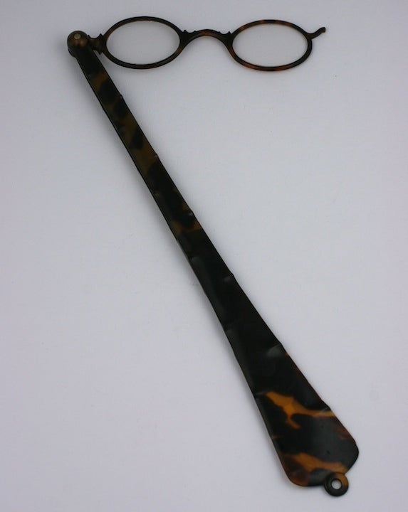 Tortoiseshell lorgnette from the late 19th Century. Glasses slide back into handle which is delicately carved in 