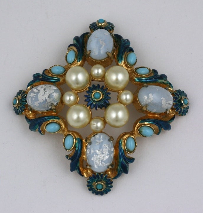Large Hattie Carnegie crest form pendant brooch of gilt metal with blue enamel,faux opals, turquoise and pearls. Has attachment for use as pendant. 1950s USA.
1950s USA. 3
