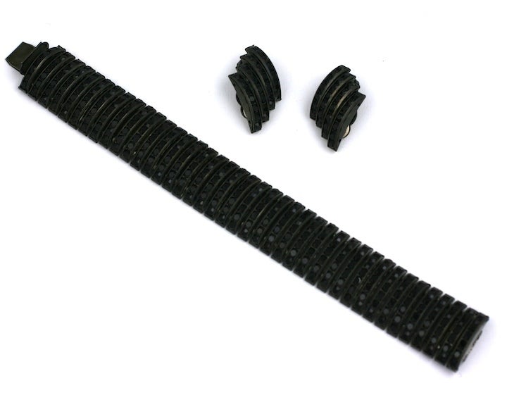 Atractivas pastas de azabache engastadas en forma de bombeta forman esta pulsera flexible de Butler & Wilson. Orejeras escalonadas a juego con chorros engarzados también.Juego en metal ennegrecido. 
Oreja 1