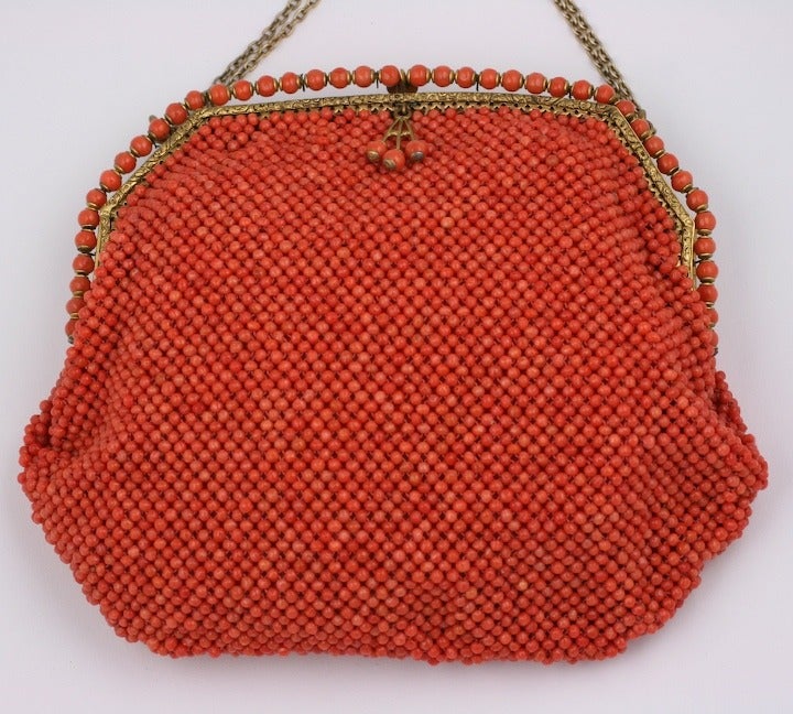 Unusual bag hand beaded of genuine coral beads from the early 20th Century. Extraordinary care has been made to match the color and size of these beads. Deceptively chic and timeless with a band of coral beads decorating the gilt bronze frame. Lined